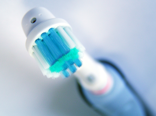 zubní kartáček elektrický s modrými štětinami a rukojetí