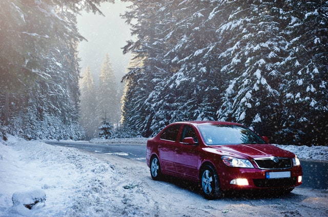 automobil v zimě na silnici v lese