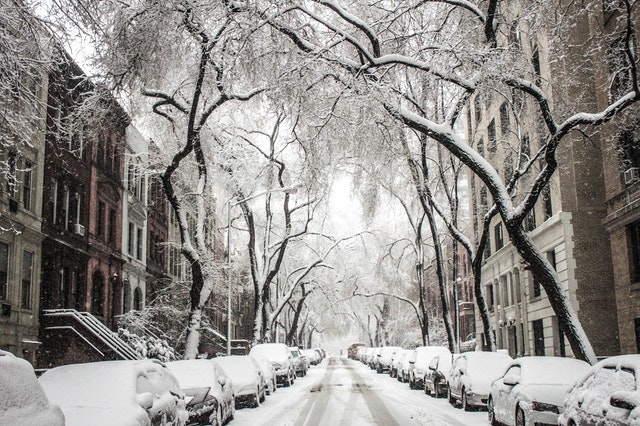 ulice se zaparkovanými auty pod sněhem